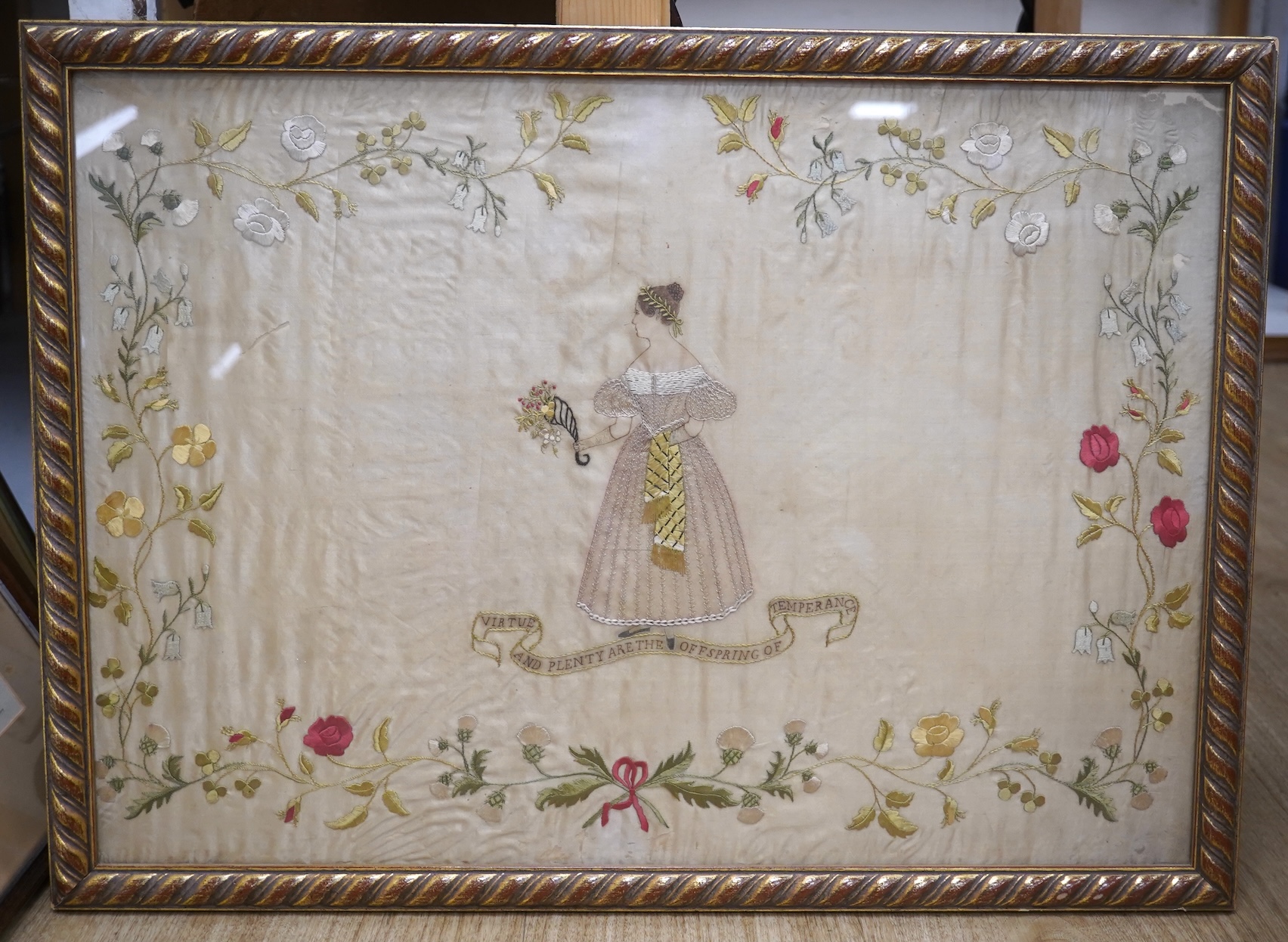 A mid 20th century, appliqué on silk 19th century lady walking in a classical garden by lake (possibly Italy), together with a silk embroidery “virtue and plenty are the off spring of temperance”, appliqué 38.5cm x 57cm.